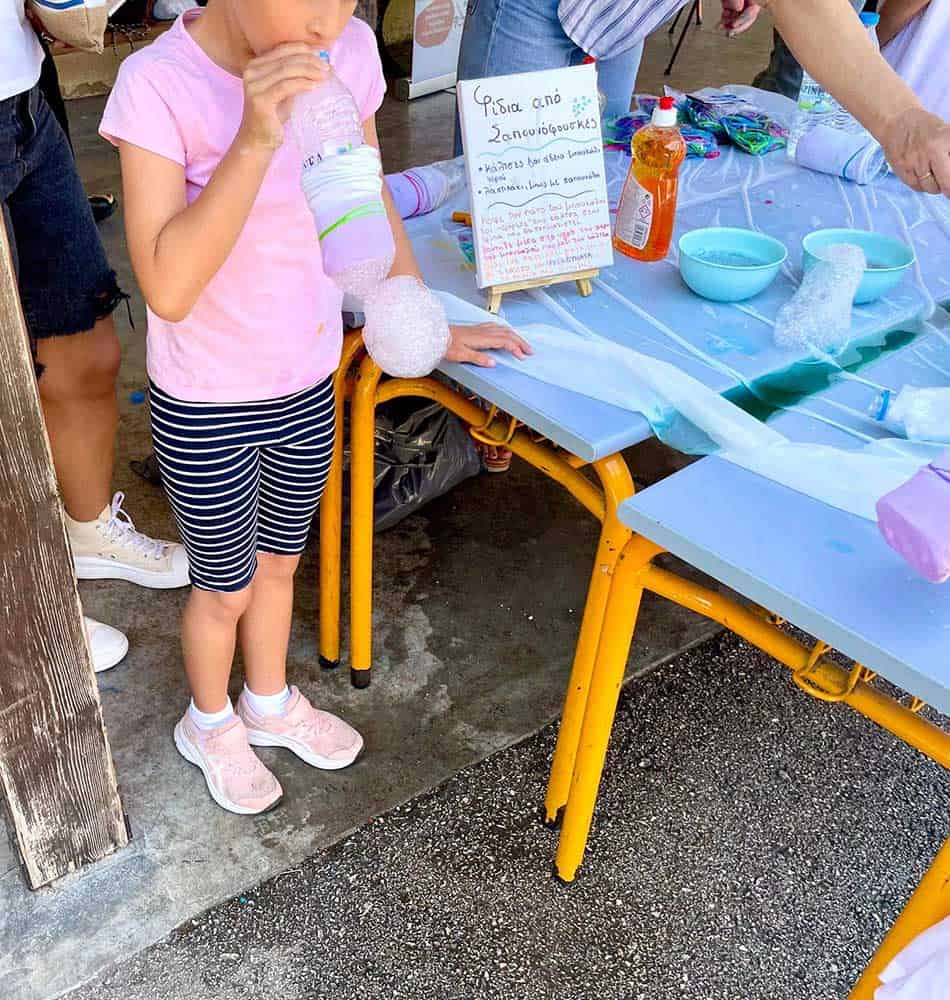 Παιδί παίζει με αφρό και νερό σε εκπαιδευτική δραστηριότητα.